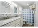 Bright bathroom showcasing a double vanity and a shower with a blue and white checkered curtain at 336 Oakwood Dr, Mount Holly, NC 28120