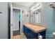 Bathroom with blue vanity featuring a tile countertop and an open doorway at 336 Oakwood Dr, Mount Holly, NC 28120