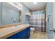 Bathroom featuring a blue vanity with a tile countertop and a shower with a striped curtain at 336 Oakwood Dr, Mount Holly, NC 28120