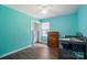 Bright bedroom featuring light blue walls, a dark wood dresser, and a changing table at 336 Oakwood Dr, Mount Holly, NC 28120
