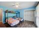 Bright bedroom featuring a bunk bed, light blue walls, and an organized closet space at 336 Oakwood Dr, Mount Holly, NC 28120