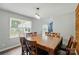 Bright dining room with large windows, hardwood floors, and a wooden table set for six at 336 Oakwood Dr, Mount Holly, NC 28120