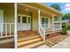 Close-up of the front entrance, showcasing a charming porch with wood stairs and a white front door at 336 Oakwood Dr, Mount Holly, NC 28120