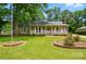 Charming single-story home with a well-manicured lawn, garden beds, and inviting front porch at 336 Oakwood Dr, Mount Holly, NC 28120