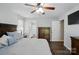 Spacious main bedroom featuring a ceiling fan, ensuite bathroom, and dark wood furniture at 336 Oakwood Dr, Mount Holly, NC 28120