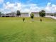 Spacious backyard with a gentle slope, featuring well-maintained green grass and several homes in the background at 417 Livingston Dr, Lancaster, SC 29720