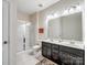 Bright bathroom with white tile, double vanity with dark cabinets, and glass-enclosed shower at 417 Livingston Dr, Lancaster, SC 29720
