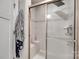 Modern bathroom featuring neutral tiling, a glass shower door, and a built-in shower seat at 4511 Hunton Dale Nw Rd, Concord, NC 28027
