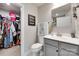 Bright bathroom with a gray vanity, mirror, and a closet with shelving for plenty of storage at 4511 Hunton Dale Nw Rd, Concord, NC 28027