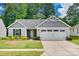 Charming one-story home with grey siding, stone accents, manicured lawn, and a two-car garage at 4511 Hunton Dale Nw Rd, Concord, NC 28027