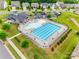 Stunning aerial view of the pool area with seating, landscaping, and a nearby clubhouse at 4511 Hunton Dale Nw Rd, Concord, NC 28027