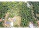 Aerial view of a wooded home with a grassy yard on a spacious lot at 4630 Irish Potato Rd, Kannapolis, NC 28083