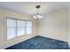 Bright dining room with large window, neutral walls, and blue carpet flooring at 4630 Irish Potato Rd, Kannapolis, NC 28083