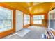Cozy sunroom with bright orange walls and plenty of natural light from multiple windows at 4630 Irish Potato Rd, Kannapolis, NC 28083