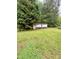 A storage building is nestled near a lush green tree in the backyard of this property at 5022 Wrenn Dr, Denver, NC 28037
