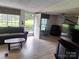 Cozy living room with neutral paint, laminated floors, and large windows at 5022 Wrenn Dr, Denver, NC 28037