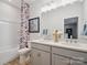 Bright bathroom with double sink vanity, modern fixtures, and a tub with a decorative shower curtain at 507 Webster Ln, Cramerton, NC 28032