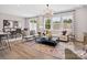 Open-concept living room featuring stylish decor, wood floors, large windows and an adjacent dining area at 507 Webster Ln, Cramerton, NC 28032