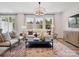 Bright living room featuring large windows, modern furniture and a stylish chandelier at 507 Webster Ln, Cramerton, NC 28032