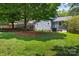Lush backyard with a mix of green grass and garden beds, offering a serene outdoor space at 6313 Weddington Rd, Concord, NC 28027