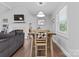 Bright dining room with hardwood floors, a wooden table with a bench, and a view of the living room at 6313 Weddington Rd, Concord, NC 28027