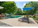 Relaxing backyard pool area featuring lounge chairs, an umbrella, and beautiful green landscaping at 6313 Weddington Rd, Concord, NC 28027