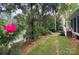 Landscaped backyard featuring a rosebush, lush greenery and a glimpse of the home's exterior at 8044 Hawk Crest Ct, Charlotte, NC 28270