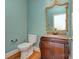 A half bathroom features a granite topped vanity with a decorative framed mirror and a toilet at 8044 Hawk Crest Ct, Charlotte, NC 28270