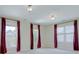 Bedroom featuring three large windows that let in lots of natural light and burgundy colored draperies at 8044 Hawk Crest Ct, Charlotte, NC 28270