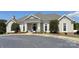 Front of the clubhouse with a stucco facade, white pillars, manicured landscaping, and ample parking at 8044 Hawk Crest Ct, Charlotte, NC 28270