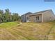 View of a large backyard and the back of the home with green grass and trees at 8450 Norman Forest Rd, Lancaster, SC 29720