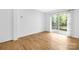 Bright bedroom with laminate floors, light walls, sliding glass door leading to the balcony at 10101 Wood Ct, Charlotte, NC 28277