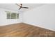 Bright bedroom with laminate flooring, a ceiling fan, white walls, and one window at 10101 Wood Ct, Charlotte, NC 28277