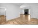 View of living room from the hallway featuring grey stone fireplace, laminate flooring, and white walls at 10101 Wood Ct, Charlotte, NC 28277