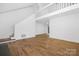 Spacious living room featuring laminate flooring, white walls, and staircase leading to second floor at 10101 Wood Ct, Charlotte, NC 28277