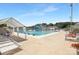 Community pool with a water slide, lounge chairs, umbrellas, and trees at 10101 Wood Ct, Charlotte, NC 28277