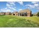A beautiful backyard with a manicured lawn, screened-in porch and outdoor fire pit area at 10106 Silverling Dr, Waxhaw, NC 28173