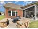 Brick home featuring a backyard fire pit, stone benches and screened-in porch for outdoor entertaining at 10106 Silverling Dr, Waxhaw, NC 28173