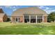 A sprawling green backyard featuring a screened-in porch and fire pit, perfect for entertaining or relaxing at 10106 Silverling Dr, Waxhaw, NC 28173