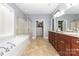 Bathroom featuring double vanity, garden tub, and separate glass shower with an open closet at 10106 Silverling Dr, Waxhaw, NC 28173