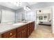 Bright bathroom with double sinks, a decorative mirror, and an entrance to the main bedroom at 10106 Silverling Dr, Waxhaw, NC 28173