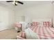 Bright bedroom featuring a ceiling fan, a vanity desk, and a bed with a cheerful red and white comforter at 10106 Silverling Dr, Waxhaw, NC 28173