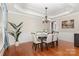 Bright dining room boasts hardwood floors, wainscoting, tray ceiling, chandelier, and natural light at 10106 Silverling Dr, Waxhaw, NC 28173