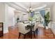 Elegant dining room featuring hardwood floors, coffered ceilings, a chandelier, and ample natural light at 10106 Silverling Dr, Waxhaw, NC 28173