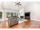 Spacious living room with a fireplace, large windows, hardwood floors, and comfortable seating at 10106 Silverling Dr, Waxhaw, NC 28173