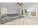 Bright living room area with a comfy gray sofa, carpet, and natural light from the large windows at 10106 Silverling Dr, Waxhaw, NC 28173