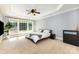 Bright main bedroom with a large window, ceiling fan, tray ceiling, and carpeted floor at 10106 Silverling Dr, Waxhaw, NC 28173