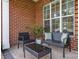Front porch featuring brick flooring, a window, a small table, and wicker seating at 10106 Silverling Dr, Waxhaw, NC 28173