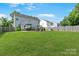 Spacious backyard with lush green grass, a fenced perimeter, and an outdoor patio seating area at 1013 Nez Perce Ln, Monroe, NC 28110