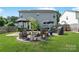 Backyard area with stone patio featuring a fire pit, comfortable seating, and an outdoor grill at 1013 Nez Perce Ln, Monroe, NC 28110